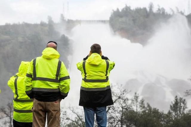 California department of water resources personnel monitor water flowing through a damaged spillway on the Oroville Dam in California, US. (Reuters Photo) California department of water resources personnel monitor water flowing through a damaged spillway on the Oroville Dam in California, US. (Reuters Photo)