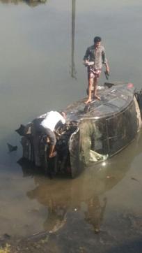 Locals trying to figure out the best possible angle to pull the car out of the river using a crane. (HT photo )