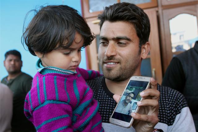 Daughter of martyr Ravi Kumar, who was killed in an encounter with militants in Bandipora district on Tuesday, looks at his picture on mobile phone in Samba district on Wednesday. (PTI) Daughter of martyr Ravi Kumar, who was killed in an encounter with militants in Bandipora district on Tuesday, looks at his picture on mobile phone in Samba district on Wednesday. (PTI)