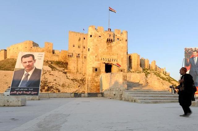 A street vendor sells coffee outside Aleppo's ancient citadel, as posters depicting Syria's President Bashar al-Assad are seen in the background, in Syria February 1, 2017. (Reuters) A street vendor sells coffee outside Aleppo's ancient citadel, as posters depicting Syria's President Bashar al-Assad are seen in the background, in Syria February 1, 2017. (Reuters)