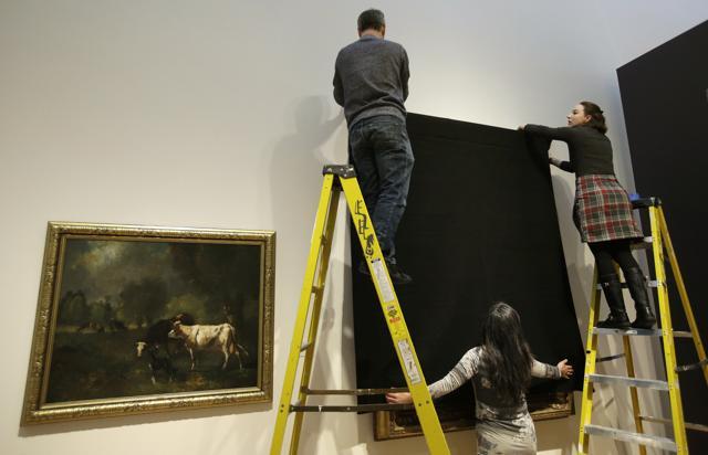 Davis Museum at Wellesley College Assistant Preparator Craig Uram, top, Curatorial Assistant Alicia LaTores, right, and Associate Director Tsugumi Joiner, below, cover the painting Friends in a Storm Approaching, 1875-1876, by Scottish-born artist James McDougal Hart, with a black shroud at the museum, in Wellesley, Mass., Thursday, Feb. 16, 2017 to protest President Donald Trump's recent travel ban. (AP) Davis Museum at Wellesley College Assistant Preparator Craig Uram, top, Curatorial Assistant Alicia LaTores, right, and Associate Director Tsugumi Joiner, below, cover the painting Friends in a Storm Approaching, 1875-1876, by Scottish-born artist James McDougal Hart, with a black shroud at the museum, in Wellesley, Mass., Thursday, Feb. 16, 2017 to protest President Donald Trump's recent travel ban. (AP)