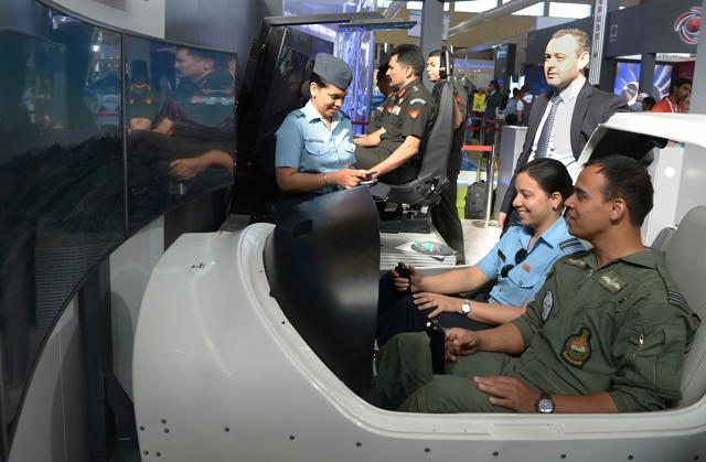 Indian Air Force (IAF) pilots sit in a flight simulator at an aviation stall in the exhibition area during the Aero India show 2017, a biennial international aerospace and defence exhibition held at Yelahanka Air Force Station in Bangalore on February 16, 2017. (MANJUNATH KIRAN / AFP) Indian Air Force (IAF) pilots sit in a flight simulator at an aviation stall in the exhibition area during the Aero India show 2017, a biennial international aerospace and defence exhibition held at Yelahanka Air Force Station in Bangalore on February 16, 2017. (MANJUNATH KIRAN / AFP)