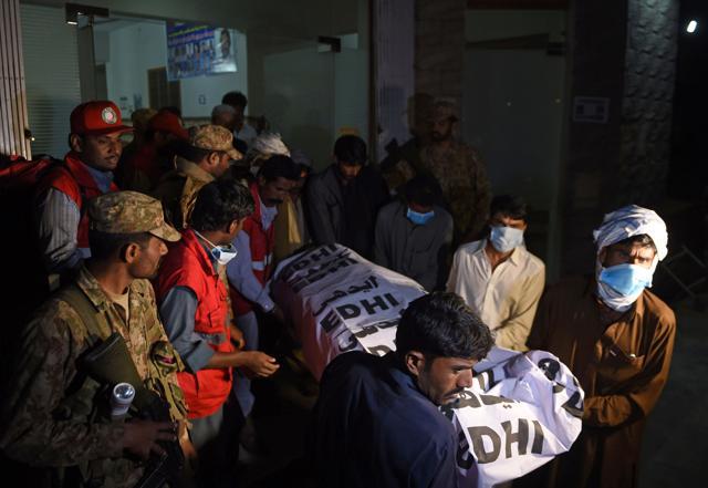 Pakistani volunteers carry the body of a victim from a hospital in the town of Sehwan. (AFP) Pakistani volunteers carry the body of a victim from a hospital in the town of Sehwan. (AFP)