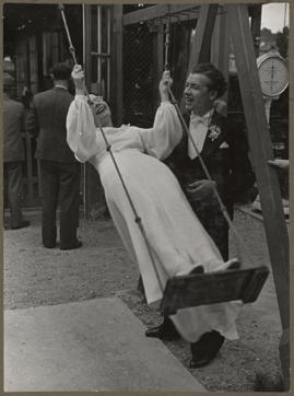 A picture of a couple where the bride swings as the groom looks on. A picture of a couple where the bride swings as the groom looks on.