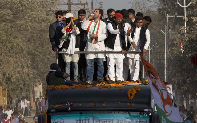 Uttar Pradesh chief minister Akhilesh Yadav, red cap, and Congress party vice president Rahul Gandhi, drinking water, cheer the crowd from a moving a vehicle during their joint election campaign in Allahabad, Uttar Pradesh. (AP Photo) Uttar Pradesh chief minister Akhilesh Yadav, red cap, and Congress party vice president Rahul Gandhi, drinking water, cheer the crowd from a moving a vehicle during their joint election campaign in Allahabad, Uttar Pradesh. (AP Photo)