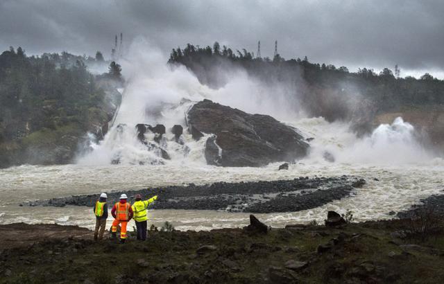 A member of Cal Fire, right, talks to workers on the Oroville Dam project in front of the main spillway in Oroville, Calif. (AP Photo) A member of Cal Fire, right, talks to workers on the Oroville Dam project in front of the main spillway in Oroville, Calif. (AP Photo)