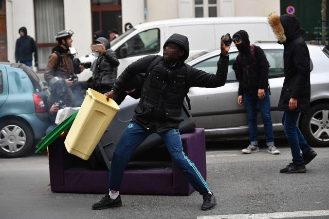 A man throws a projectile at riot police during a protest by students against police brutality in Paris on Thursday. (AFP)