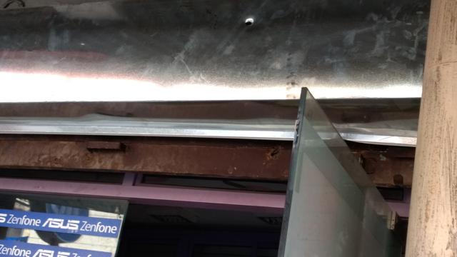 One of the bullets pierced through the iron shutter of a mobile shop. (HT Photo) One of the bullets pierced through the iron shutter of a mobile shop. (HT Photo)