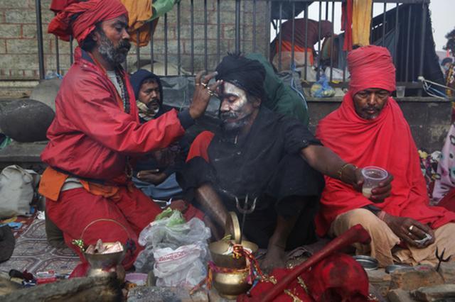 A sadhu helps another smear his body with ash and vermilion powder at the courtyard of the Pashupatinath Temple in Kathmandu during Mahashivratri on Friday. (AP) A sadhu helps another smear his body with ash and vermilion powder at the courtyard of the Pashupatinath Temple in Kathmandu during Mahashivratri on Friday. (AP)