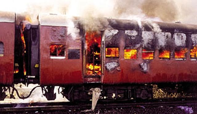 Smoke pours from the carriage of a train on fire in Godhra, in Gujarat, February 27, 2002. (Reuters) Smoke pours from the carriage of a train on fire in Godhra, in Gujarat, February 27, 2002. (Reuters)