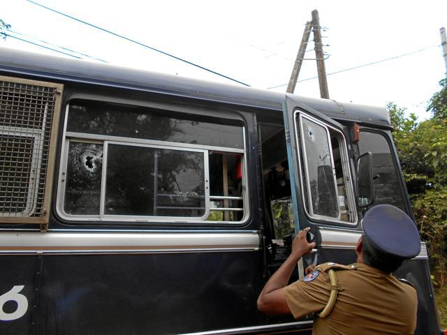 A police officer inspects the prison bus after gunmen opened fire in Colombo. (Reuters Photo)