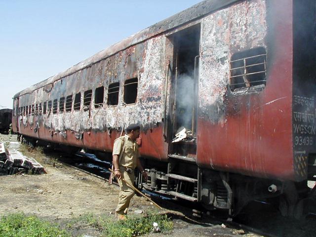 A policeman walks towards the entrance of a carriage of a train in Godhra, Gujarat, February 27, 2002. A policeman walks towards the entrance of a carriage of a train in Godhra, Gujarat, February 27, 2002.