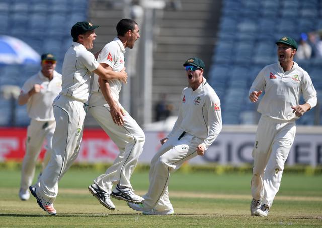 Australia's Mitchell Starc (2L) celebrates with teammates Steve O'Keefe (L), captain Steve Smith (2R) and Shaun Marsh (R) after the dismissal of India's captain Virat Kohli during the second day of the first cricket Test match between India and Australia in Pune on February 24. (AFP)