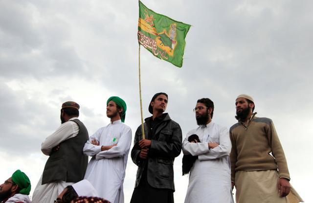 A man holds a religious flag as he attends a gathering to mark the anniversary of Mumtaz Qadri’s death. (REUTERS) A man holds a religious flag as he attends a gathering to mark the anniversary of Mumtaz Qadri’s death. (REUTERS)