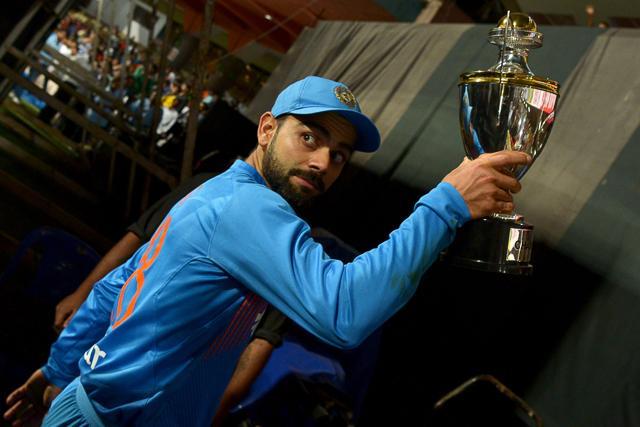 Virat Kohli walks back to the pavilion with the trophy after winning the third T20 vs England at the Chinnaswamy Stadium in Bangalore on February 1, 2017. (AFP) Virat Kohli walks back to the pavilion with the trophy after winning the third T20 vs England at the Chinnaswamy Stadium in Bangalore on February 1, 2017. (AFP)