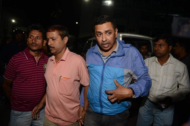 CID officials escort district child protection officer of Darjeeling district, Mrinal Ghosh (in blue jacket) from a police station in Siliguri on Friday night. (AFP) CID officials escort district child protection officer of Darjeeling district, Mrinal Ghosh (in blue jacket) from a police station in Siliguri on Friday night. (AFP)
