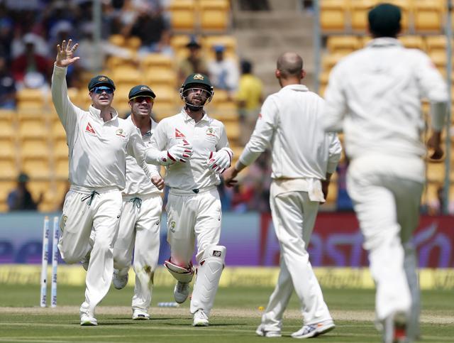 Australia's captain Steven Smith, left, celebrates with teammates the dismissal of India's Ajinkya Rahane during the first day of their second Test in Bangalore, Saturday. (AP) Australia's captain Steven Smith, left, celebrates with teammates the dismissal of India's Ajinkya Rahane during the first day of their second Test in Bangalore, Saturday. (AP)
