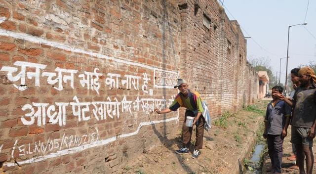 Mustafa busy with his wall writing. (Diwakar Prasad/ HT Photo)