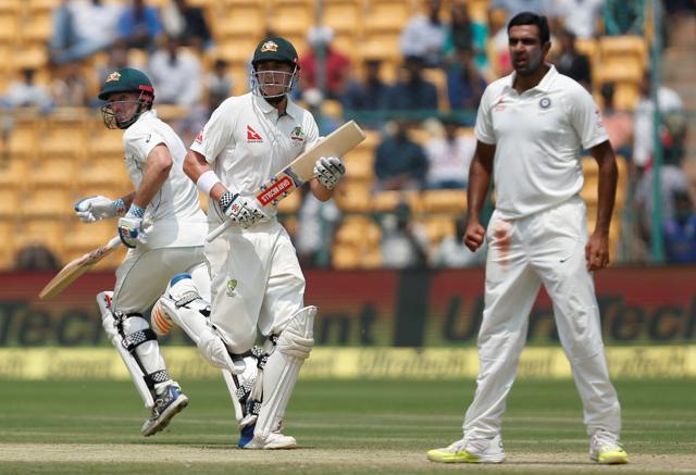 Australia's Matt Renshaw and Shaun Marsh run between the wickets as India's Ravichandran Ashwin looks on in Bangalore. (REUTERS)