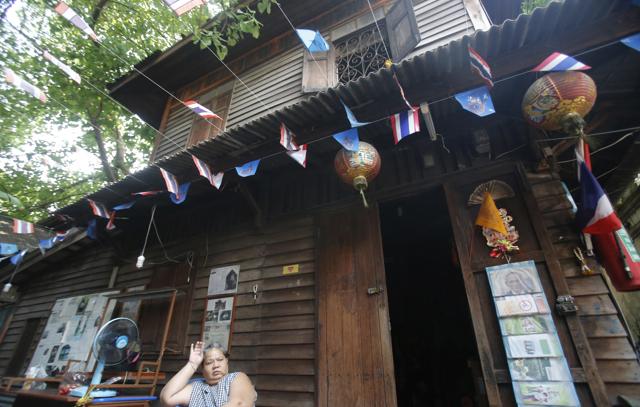 A resident sits in front of her house at Fort Mahakan in Bangkok, Thailand. (AP Photo)