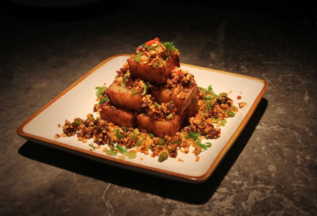 The fried turnip cakes are well-seared and seasoned, topped with a little mountain of fried garlic and spring onion, and just enough chilli oil. (Bhushan Koyande / HT Photo )