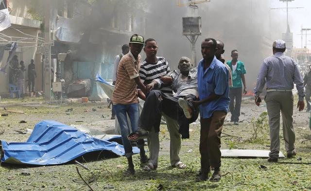 Rescuers carry an injured man from the scene of an explosion in Mogadishu. (REUTERS)