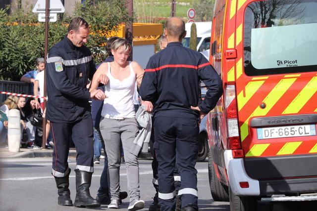Firefighters help a person to walk toward a vehicle near the Tocqueville high school in the southern French town of Grasse. (AFP Photo)