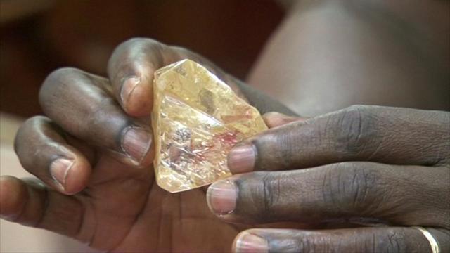 In this photo taken from video footage, Sierra Leone's President Ernest Bai Koroma hands a diamond during a meeting with delegates of Kono district, where the gem was found, at the presidential office in Freetown, Sierra Leone. (AP)