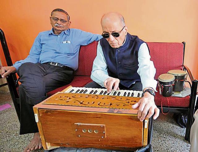 Sometimes, the companion is another senior, looking for companionship himself. Here, Vidyadhar Joshi from Maya Care helps Sudhakar Kulkarni, 74, practise bhajans at his Pune home. (HT Photo)