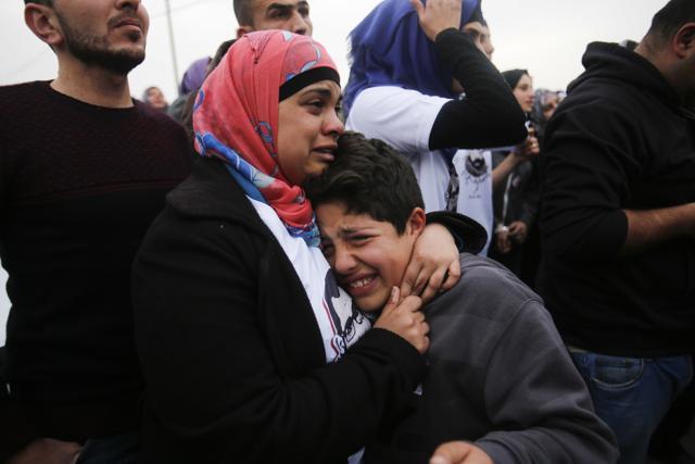 Palestinians cry during then funeral of Basil al-Araj in the West Bank village of Walajeh, near Bethlehem, on March 17. (AP Photo)