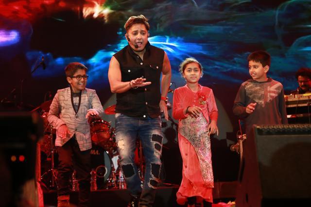 Singer Sukhwinder Singh shakes a leg on stage with some children. (Amal KS/HT Photo)