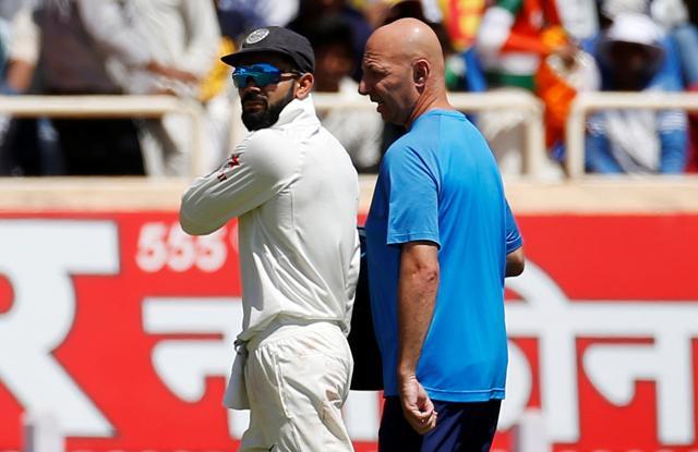 Virat Kohli walks off the field along with physio Patrick Farhart after injuring himself in the Ranchi Test. (REUTERS) Virat Kohli walks off the field along with physio Patrick Farhart after injuring himself in the Ranchi Test. (REUTERS)