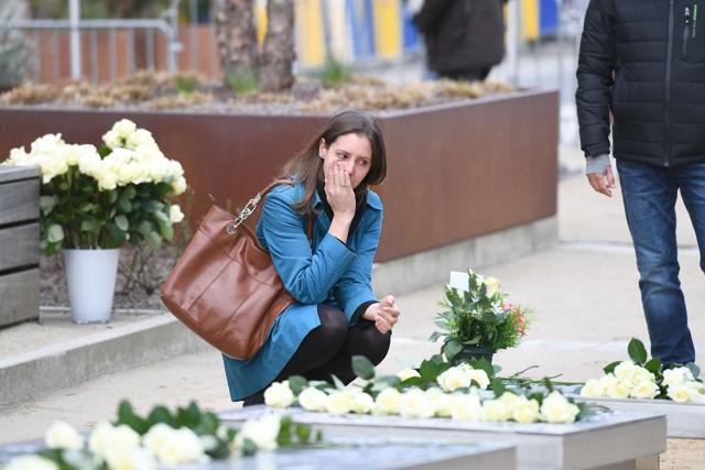 A woman pays her respects at a memorial near the European Union institutions as the country marks the first anniversary of the twin Brussels attacks by Islamic extremists on March 22, 2017. (AFP Photo)