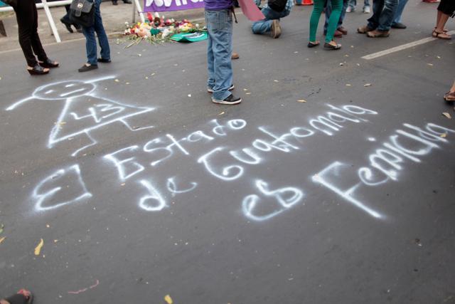 Activists stand next to a graffiti on a street during a protest outside of Guatemala's embassy in Managua to demand justice for the victims of a fire at the Virgen de Asuncion children shelter in Guatemala. (Reuters Photo)