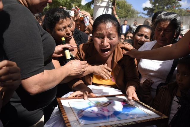 Marta Lidia Garcia (centre) cries over the coffin of her 17-year-old daughter Siona Hernandez, who died in a fire at a state-run shelter, during her funeral at the general cemetery in Guatemala City. (AFP Photo)