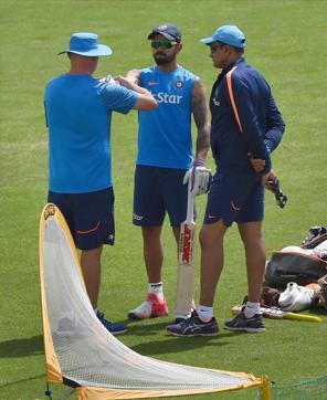 Virat Kohli takes aid from team physiotherapist Patrick Farhart as coach Anil Kumble looks on during a practice session at HPCA Stadium in Dharamsala on Thursday. (PTI) Virat Kohli takes aid from team physiotherapist Patrick Farhart as coach Anil Kumble looks on during a practice session at HPCA Stadium in Dharamsala on Thursday. (PTI)