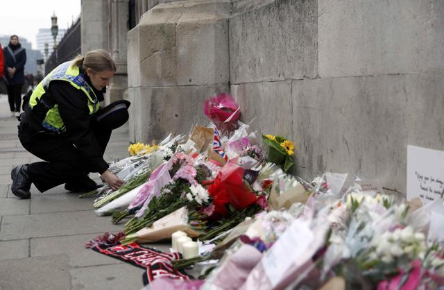 A police officer lays a floral tribute near Westminster Bridge following a recent attack in Westminster, in London. (REUTERS) A police officer lays a floral tribute near Westminster Bridge following a recent attack in Westminster, in London. (REUTERS)