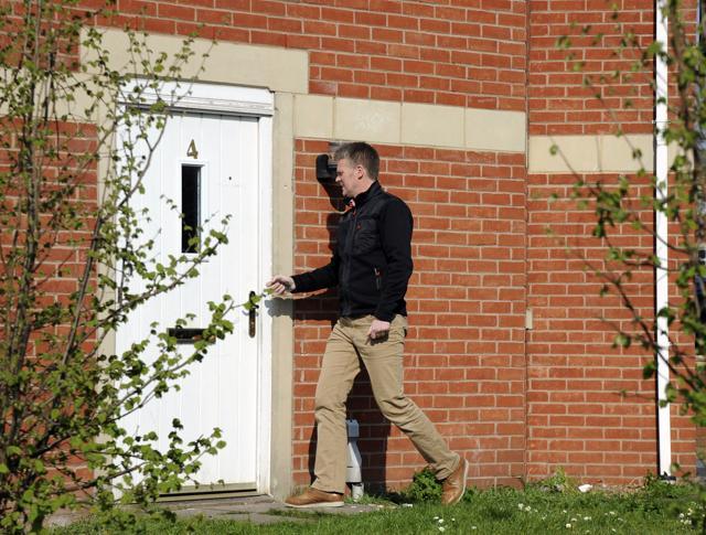 A police officer enters the house in Quayside where Khalid Masood lived, in Birmingham, England. (AP Photo)
