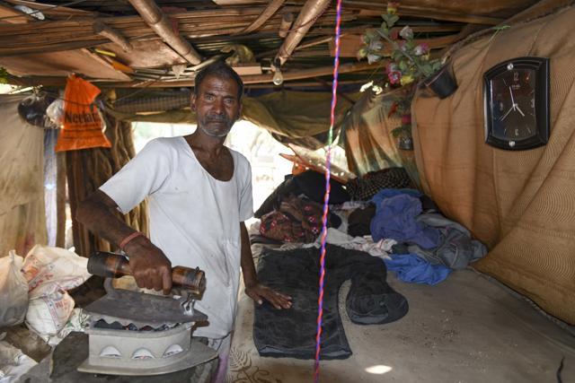 Rukampal, who runs an ironing stall, cannot claim his pension because of an error in his year of birth on his Aadhaar card. (Arun Sharma/HT PHOTO)