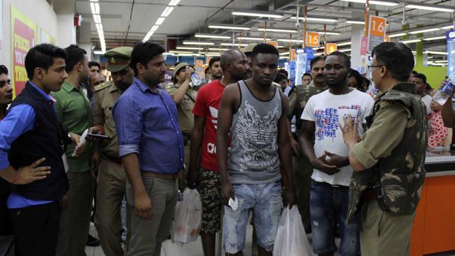 African nationals talk to a policeman after a suspected racial attack on them, in Greater Noida on Monday. (HT Photo) African nationals talk to a policeman after a suspected racial attack on them, in Greater Noida on Monday. (HT Photo)