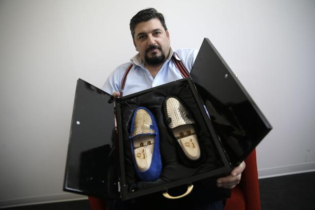 Antonio Vietri, artisan and founder of A&amp;V Fashion, shows men shoes as part of his collection "Gold". (AFP Photo)