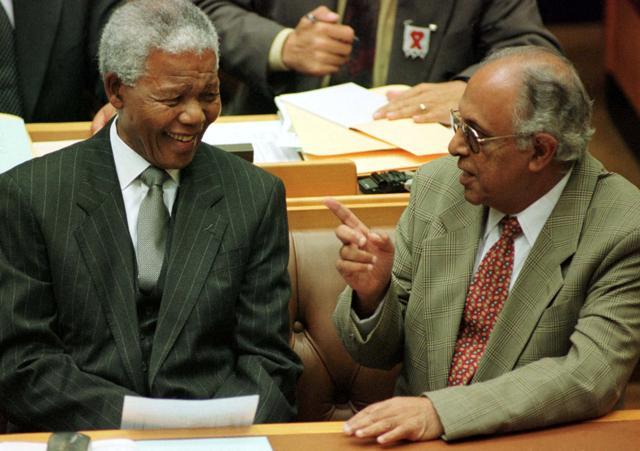 Former South African President Nelson Mandela talks to fellow veteran politician Ahmed Kathrada before Mandela's address to Parliament in Cape Town March 2, 1999. (Reuters FIle Photo)