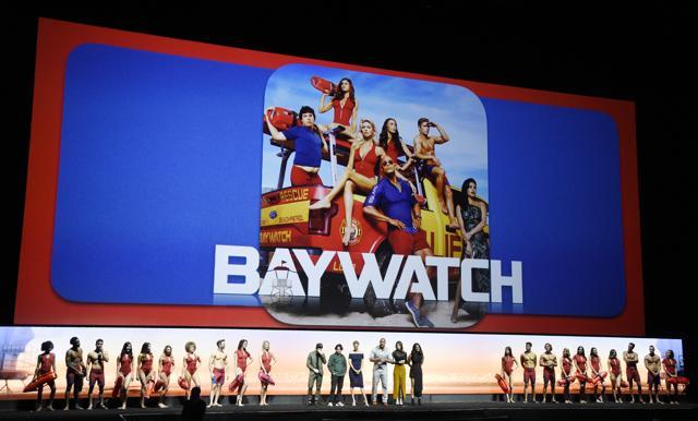 The cast of Baywatch flanked by models dressed as lifeguards during the Paramount Pictures presentation at CinemaCon 2017. (Chris Pizzello/Invision/AP)