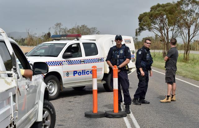 Police man a road block at floodwaters near the Queensland town of Bowen on March 29, after the area was hit by Cyclone Debbie. (AFP Photo) Police man a road block at floodwaters near the Queensland town of Bowen on March 29, after the area was hit by Cyclone Debbie. (AFP Photo)