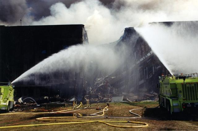 Firefighters douse the flames after the plane slammed into the iconic five-sided building housing the headquarters of the US defense department. (FBI Records)