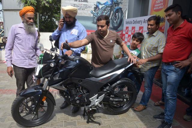 Customers check out a BS-III standard motorcycle being offered at a discount at a showroom in Amritsar. (Narinder Nanu / AFP) Customers check out a BS-III standard motorcycle being offered at a discount at a showroom in Amritsar. (Narinder Nanu / AFP)