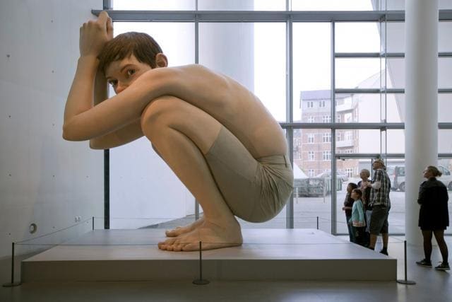 Visitors look at the hyper-realistic sculpture of Ron Mueck titled Boy at the ARoS Aarhus Kunstmuseum in Aarhus, Denmark. (Shutterstock) Visitors look at the hyper-realistic sculpture of Ron Mueck titled Boy at the ARoS Aarhus Kunstmuseum in Aarhus, Denmark. (Shutterstock)