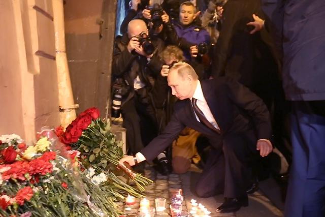 Russian President Vladimir Putin places flowers in memory of victims of the blast in the Saint Petersburg metro outside Technological Institute station on April 3, 2017. (AFP)