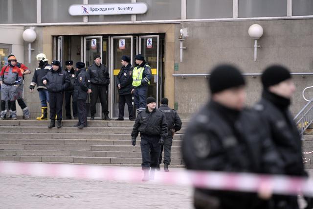 Police officers guard the entrance to Sennaya Square metro station in Saint Petersburg on April 3, 2017. Russia's Investigative Committee said Monday it was probing a suspected "act of terror" after a blast in the Saint Petersburg metro killed 11 people and injured dozens. (AFP)