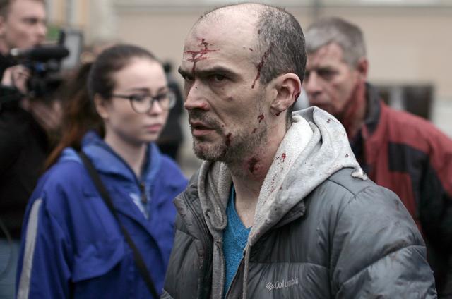 An injured man is helped by medics outside Technological Institute metro station in Saint Petersburg on April 3, 2017 (AFP)